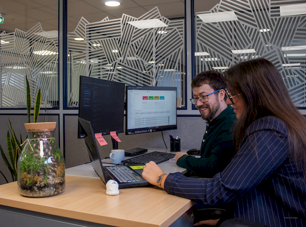 Collaboration directe entre un développeur et un client réfléchissant à la conception de leur application sur mesure